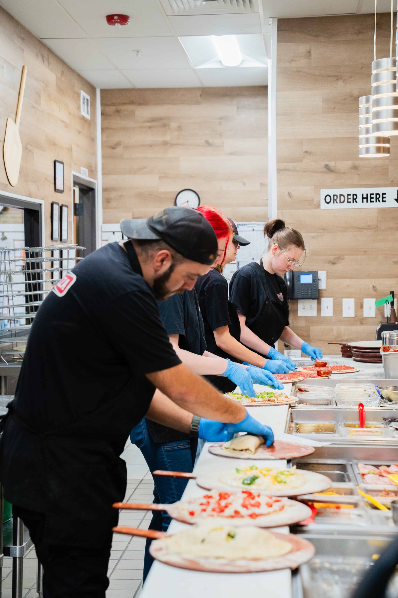 Ben's Brick Oven Pizza team members providing friendly service in a warm restaurant environment